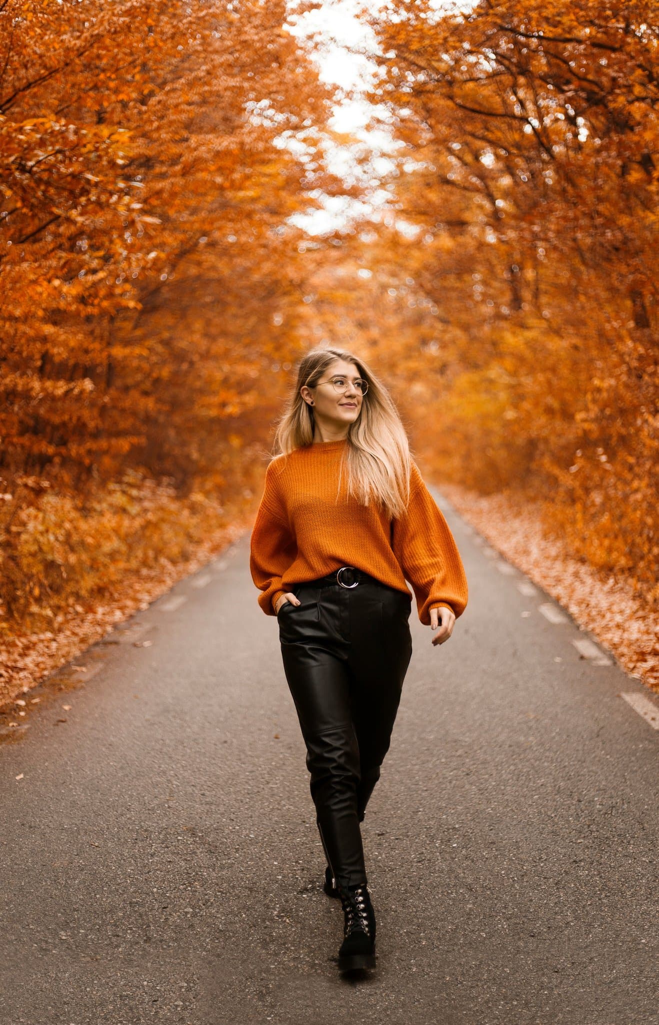 Autumn tunnel of orange foliage framing a relaxed walk in soft daylight.