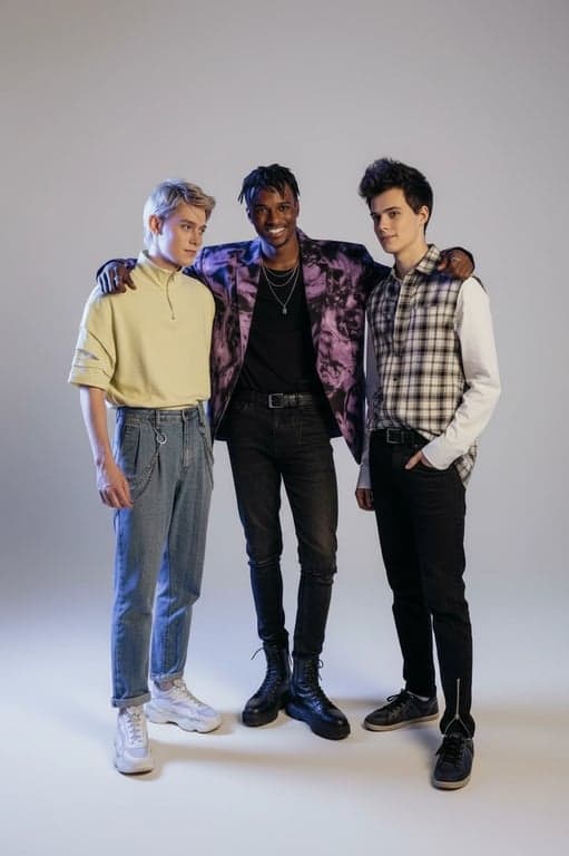 a portrait of multiple men transformed into a balanced K-pop boy group fashion set, with tailored proportions, cohesive styling direction, visible garment structure, neutral background, and professional idol presentation