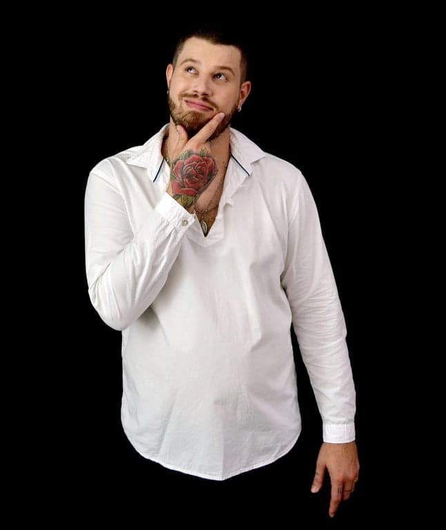 AI ugly filter before photo- man in white shirt smiling with crossed arms