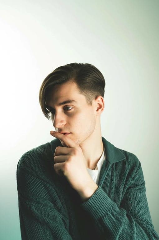 a portrait of a man edited in a Korean side-swept men hairstyle style, so that the top hair is straight and brushed to one side, with the fringe covering one side of the forehead as seen in Korean men styling, the opposite side and back trimmed short and straight, no curls or waves, and unchanged face and original lighting