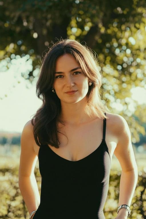 a portrait of a person transformed by dramatically lowering the hairline, filling in the upper forehead area so the hair coverage extends downward and creates a denser, fuller hair appearance that reduces face size