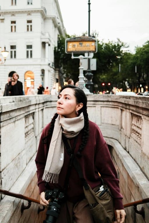 a portrait of a person wearing smart casual attire, standing in a pleasant urban park or street, with a friendly and confident demeanor