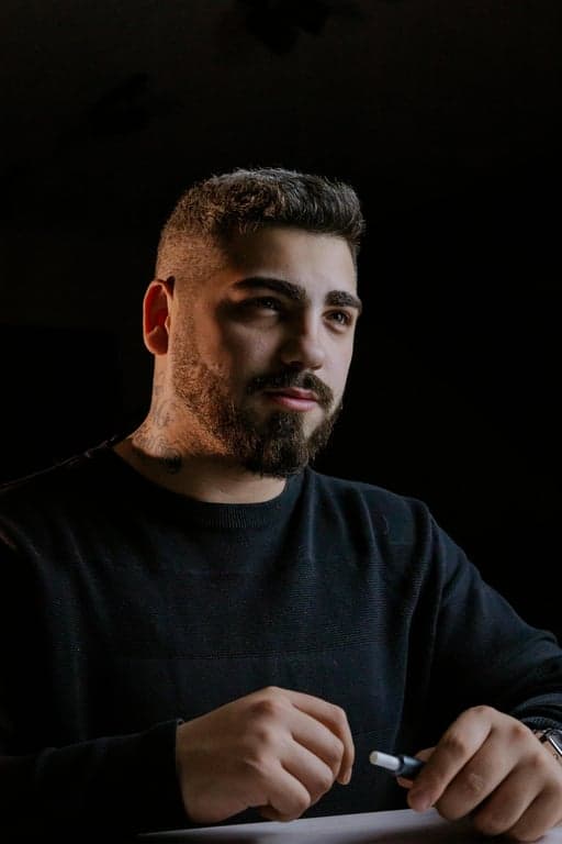 a portrait of a person edited to change the face shape from a round or wide appearance into a sharp V-shaped face, significantly narrowing the jaw and lower cheeks, pulling both sides inward to form a pointed chin shape, keeping forehead width unchanged, eyes nose and mouth in the same position, with a clearly visible before-and-after difference