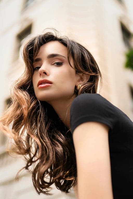 a portrait of a person wearing a Korean casual-chic outfit with long coat, straight inner dress, minimal detailing, clean lines, muted color palette, balanced proportions, calm urban lighting