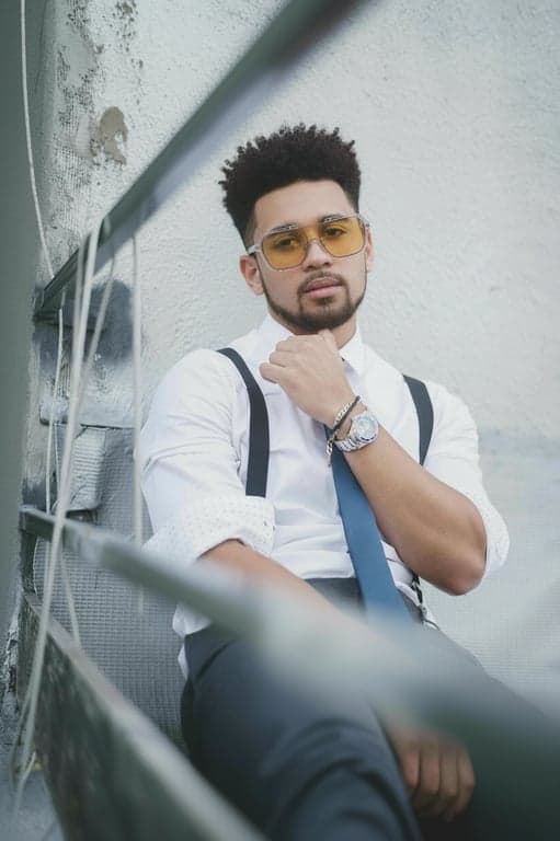 a portrait of a person photographed at eye level in a head-and-shoulders crop; increase hair volume only by enhancing strand density and fullness at the crown and mid-length areas; lift roots slightly to create visible thickness; preserve original hairline shape, hairstyle, and hair length; do not modify face, pose, background, or clothing; avoid inflated, helmet-like hair shapes; maintain realistic strand separation, flyaways, and natural hair flow; lighting unchanged; result should look like naturally fuller hair, not restyled hair