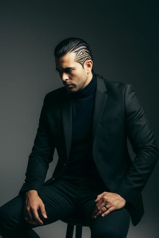 A detailed visualization of a geometric cornrow design on a man's shaved sides, intricate lines and shapes, high-definition detail, studio portrait.