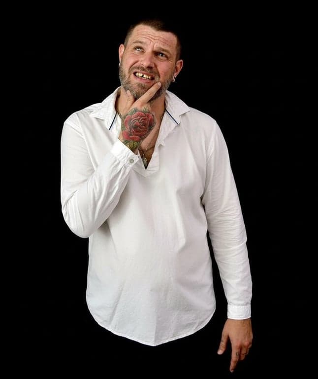 AI ugly filter after photo- distorted-faced man in white shirt laughing