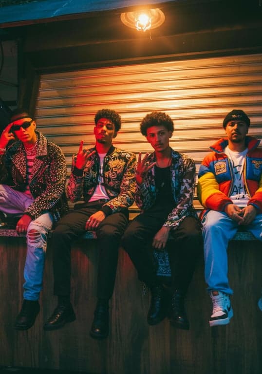 a portrait of multiple men styled with expressive K-pop boy group fashion elements, statement jackets, layered textures, clear styling logic, confident stance, and balanced lighting