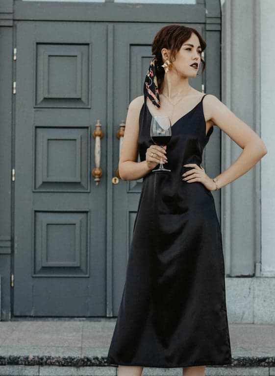 A portrait of a person fully transformed into a true My Little Pony–style animated pony, enforcing strict quadruped anatomy with four hooves on the ground, horizontal spine, rounded barrel body, oversized head and eyes, rounded muzzle, no arms, no hands, no fingers, no humanoid limbs, no upright posture, identity mapped only through eye expression, mane shape derived from original hairstyle, and color palette inspired by the original image, preserving the original background, camera angle, and lighting, rendered in flat pastel cel-shaded cartoon style with clean bold outlines and a personalized cutie mark on the flank.