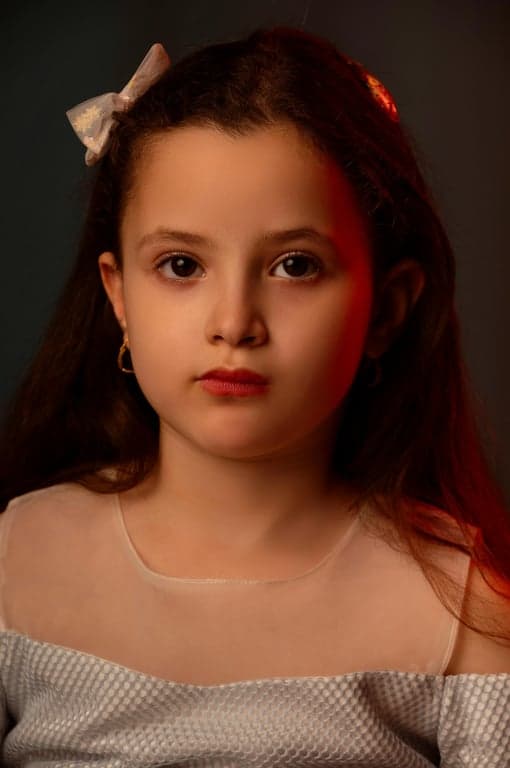 a portrait of a person transformed with elegant magical girl visuals, wearing a refined anime costume with structured silhouette, decorative ribbons, gloves, boots, fantasy outfit details, and luminous anime-style lighting