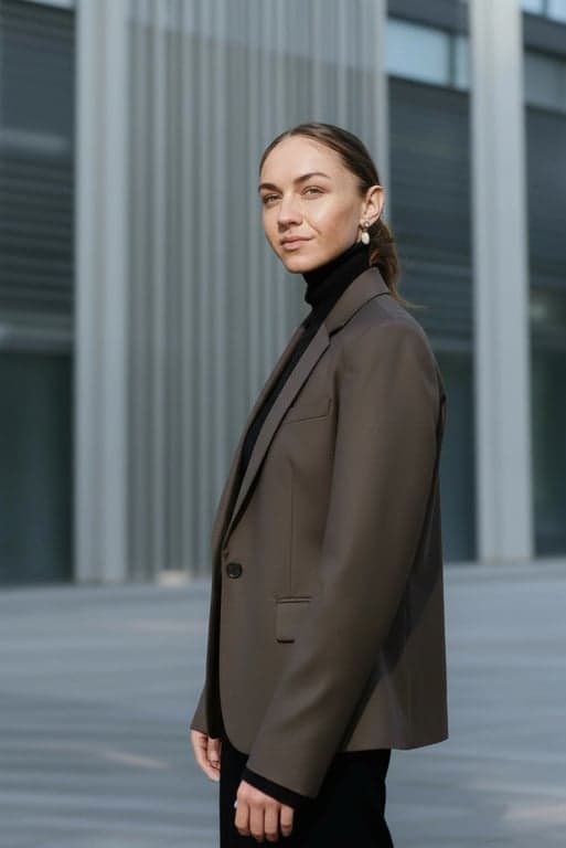 a portrait of a person styled in a minimalist fashion look with sharp tailoring, balanced proportions, smooth texture, understated details, composed standing pose, modern ambient lighting