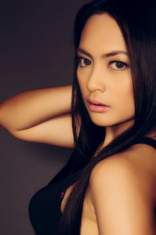 A high-fidelity digital ID photo of a woman, pixel-perfect clarity, natural skin tone without filters, hair away from face, solid light blue background.