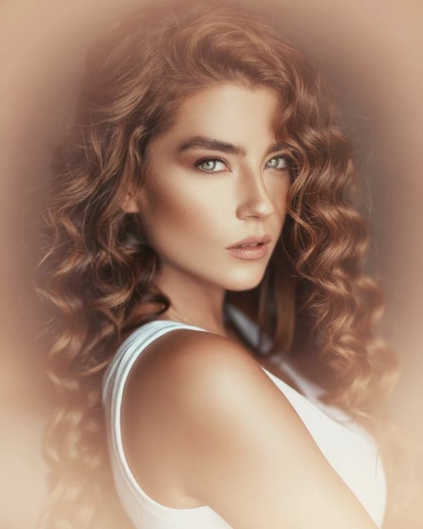 A warm aesthetic portrait of a woman, peach and gold color grading, soft focus on edges, radiant complexion, dreamy and romantic style.