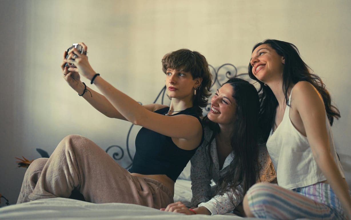 Stewie and Brian characters (or style analogs) sitting on the couch watching TV, with the classic simplistic furniture and window view of Quahog.