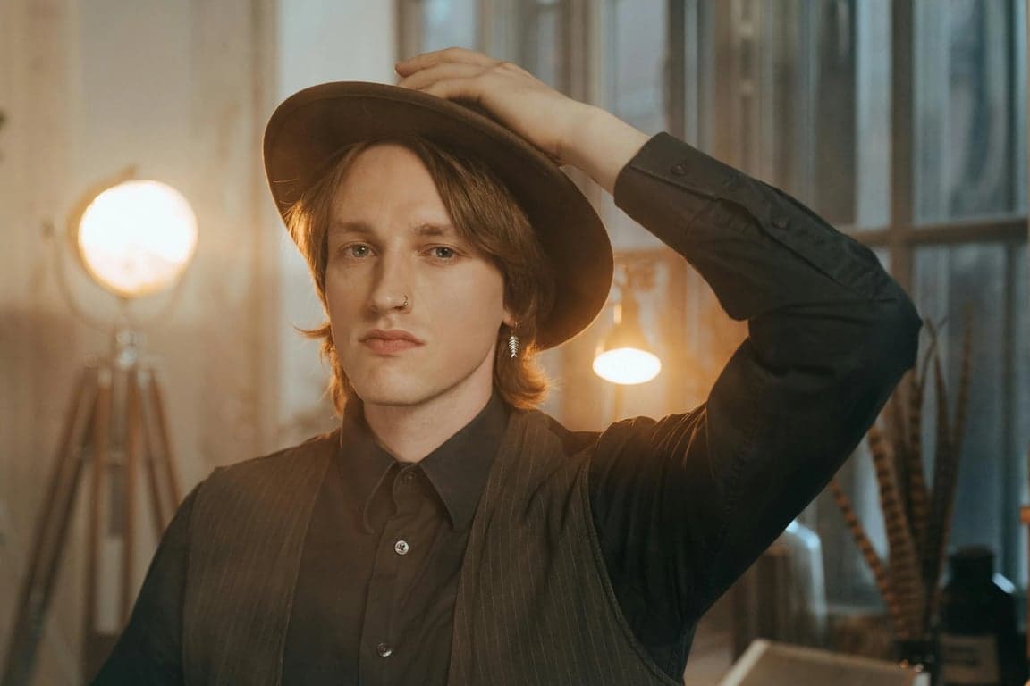 a portrait of a person illustrated in My Hero Academia style with thick-to-thin ink lines, expressive eyebrows and eyes, simplified nose and mouth shapes, and clean cel-shaded tones; lighting high-contrast but readable; background minimal anime gradient; heroic composition and confident posture