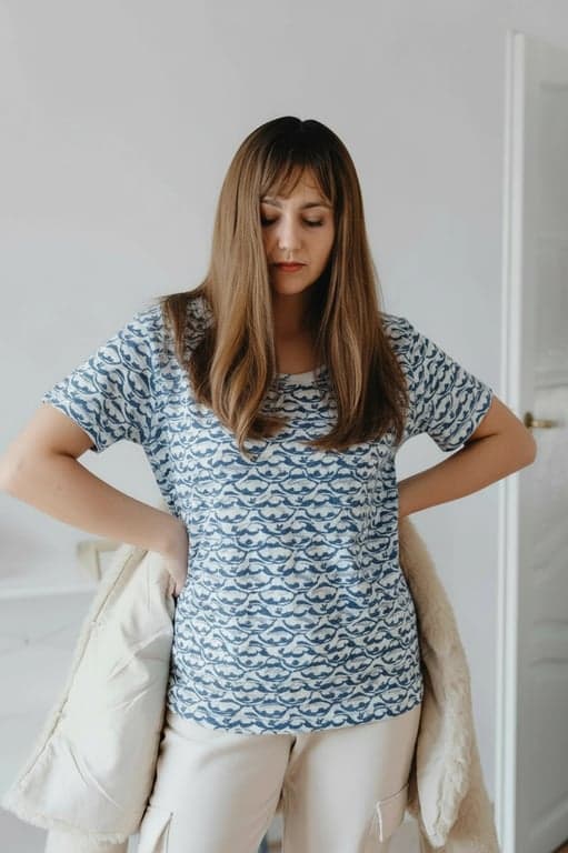 a portrait of a person edited with a patterned T-shirt design, featuring evenly spaced or intentionally arranged pattern elements, correct perspective wrapping across the torso, consistent scale, natural interaction with fabric wrinkles, preserved shirt texture, and balanced lighting
