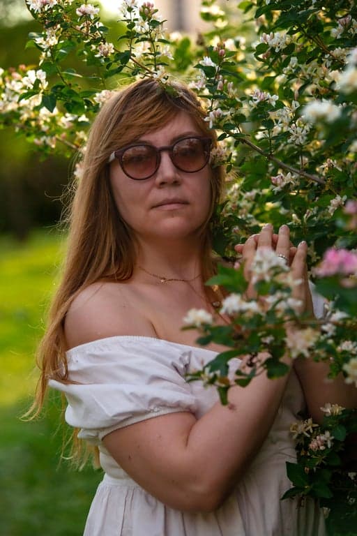 a portrait of a person edited to significantly slim the chin and under-jaw area by reducing submental fullness and carving a clearer jaw-to-neck boundary; visually lift the chin area to remove heaviness; keep jaw width and chin projection realistic; preserve natural skin texture and tone; avoid stretched or pulled neck artifacts; keep background completely unchanged; the result should show an obvious reduction of double chin while remaining believable