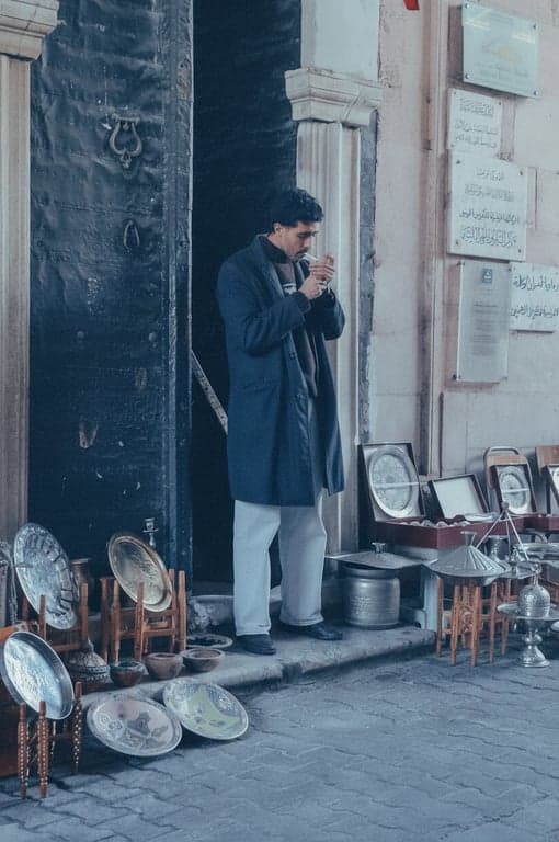 a portrait of a man edited with a cool-toned film grain effect, featuring blueish shadows, fine grain, and a nostalgic fade