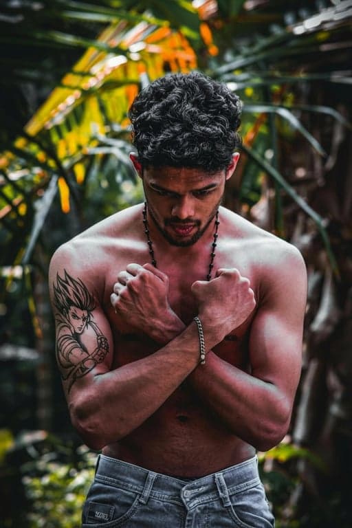 anime tattoo after photo - man crossing arms with anime tattoo