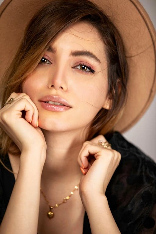 a portrait of a person in a minimalist casual look featuring oversized knit top, straight trousers, controlled drape, muted palette, relaxed elegance, natural indoor light