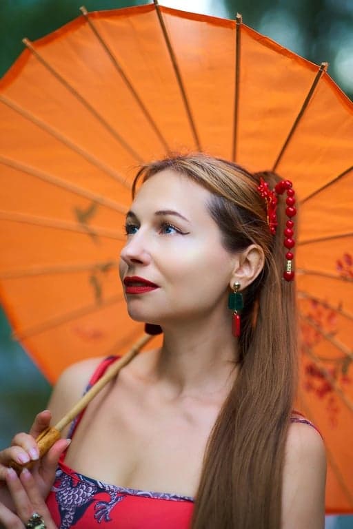 ai eye contact correction before photo - woman holding an orange umbrella