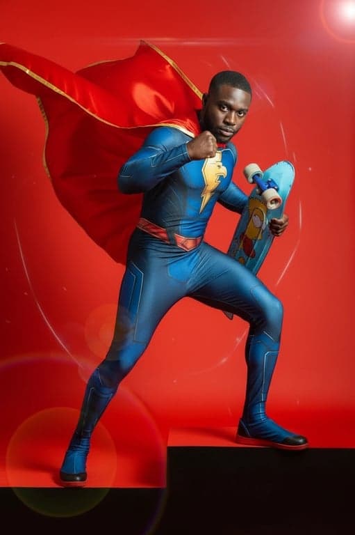 a portrait of a person in a superhero cosplay from comics or movies, featuring spandex suit, cape, and emblem, in a heroic stance