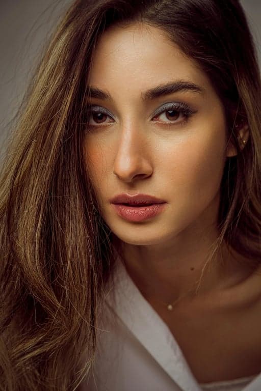 a portrait of a person enhanced with editorial aesthetic outfit styling, carefully curated clothing details, subtle contrast, composed pose, soft studio lighting, and a clean editorial background