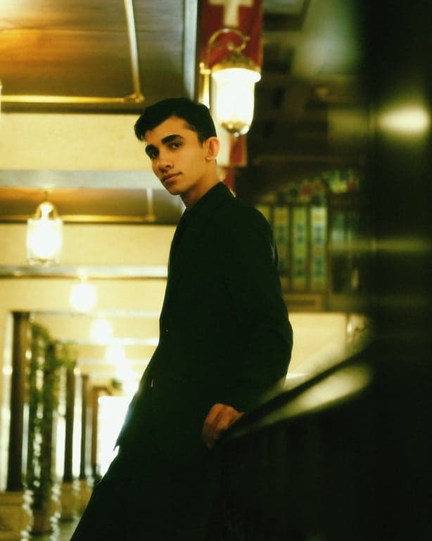 a portrait of a person illustrated in a Grant Wood–inspired American Gothic style with stiff pose, direct gaze, smooth realistic surfaces, minimal visible brush texture, muted midwestern tones, clear contours, and a disciplined traditional American painting look