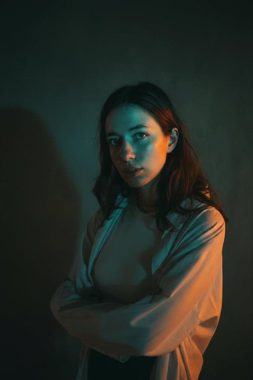 A cinematic headshot of a woman, with a teal color cast in the midtones and vibrant orange highlights, chiaroscuro lighting effect, filmic texture, neutral environment.