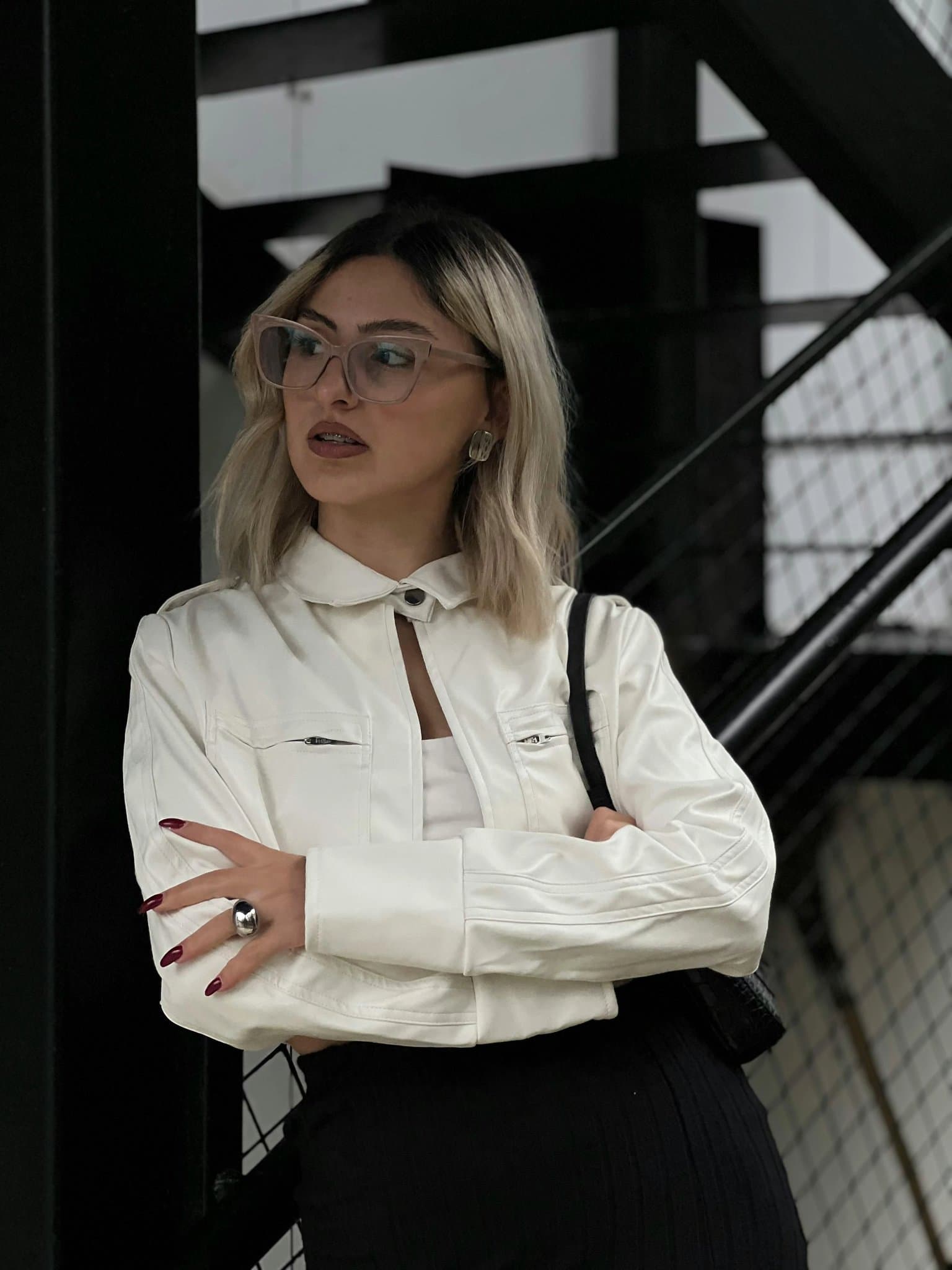 A photo of a female standing in trousers and a blouse.
