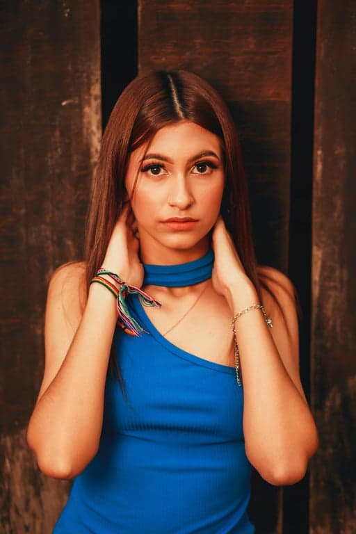 a portrait of a person reimagined as a DC superhero comic character with exaggerated heroic proportions, sharp facial geometry, intense gaze, bold contour lines, deep shadows, controlled highlights, and a dark cinematic comic book mood