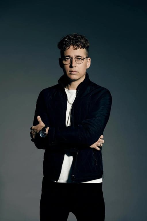 a portrait of a man edited in a Korean perm hairstyle style, so that the top hair has small even waves forming soft curls as seen in Korean men perm cuts, while the sides and back are cut short and remain straight, with curl texture limited only to the top area, and unchanged face and original lighting