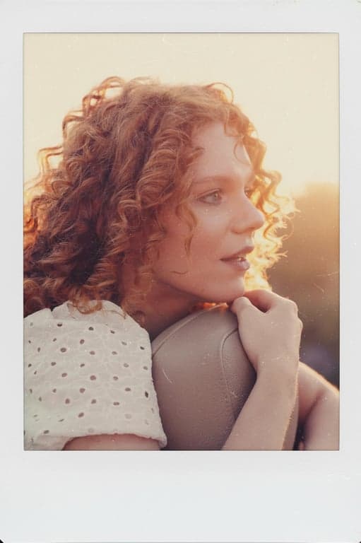 a portrait of a person styled as a clean Polaroid instant image with gentle color shifts and subtle film texture