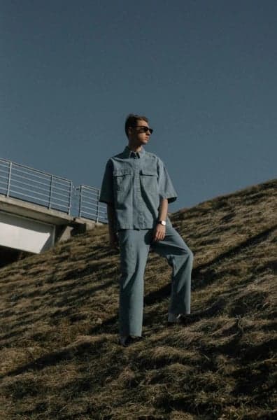 a portrait of a person illustrated in a Demon Slayer–style anime aesthetic, emphasizing movement, fabric flow, and high-contrast shading