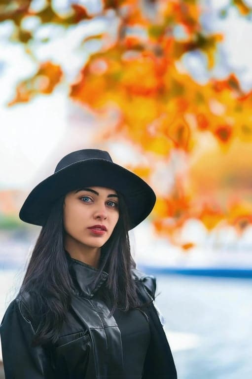 a portrait of a person enhanced to appear significantly leaner under the chin by compressing submental volume and strengthening the jaw-to-neck boundary; maintain jaw geometry and chin projection; preserve natural skin texture and lighting behavior; avoid cosmetic smoothing; do not modify the background; result should look like a strong but believable facial improvement